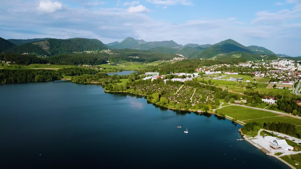 toma de paisaje aéreo de la costa del lago velenjsko con la ciudad y las colinas en el fondo eslovenia europa
