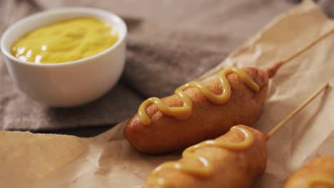 video of corn dogs with dip on a wooden surface