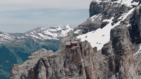 retiro tiro en círculo de la cabaña alpina con vistas a acantilados escarpados y valles verdes