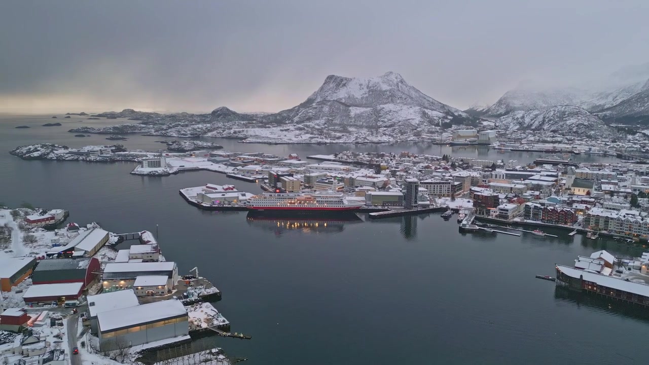 Vinterlig flyfoto av Lofoten, Norge, som viser en fredelig snødekt havn.