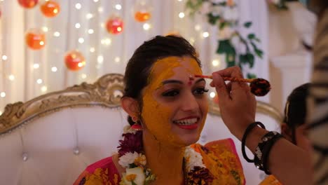 Applying-a-Red-Dot-to-the-Indian-Bride-During-the-Pithi-Ceremony---Close-Up