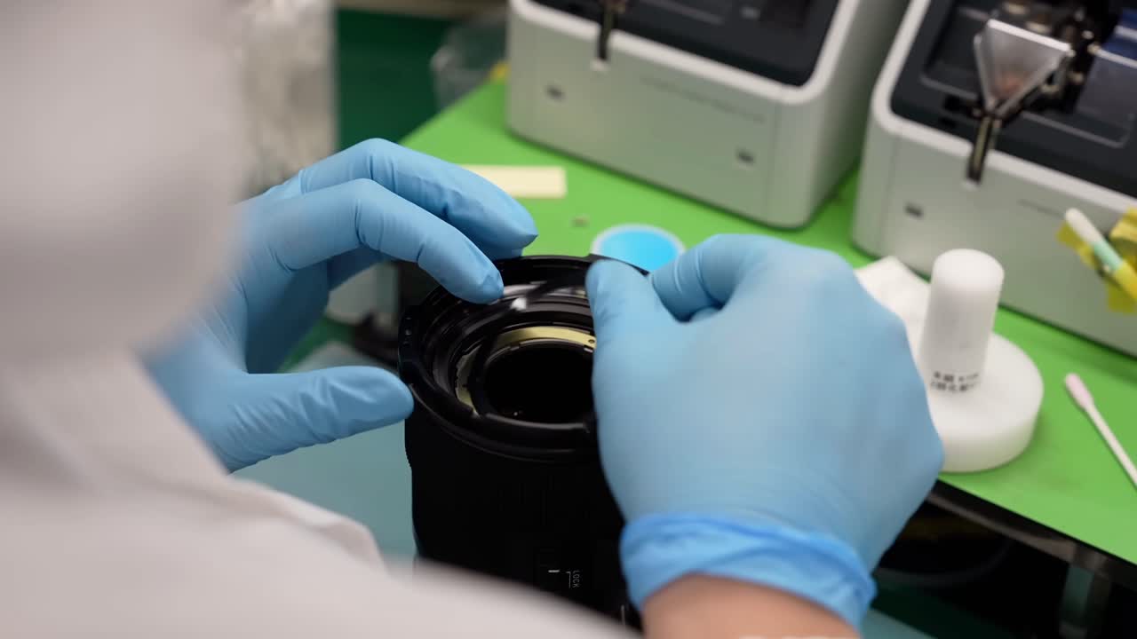 A close-up of a worker attaching washers to lenses