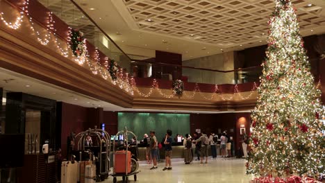 people gathering around a large christmas tree