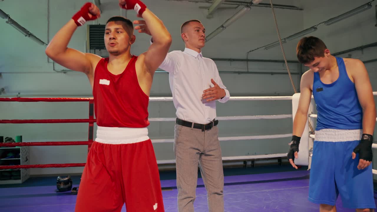 Combate de boxeo con el árbitro anunciando al ganador