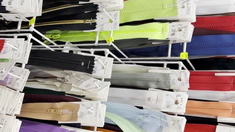 many different zippers for clothes of different sizes and colors zippers on racks in the workshop many different zippers for clothes in different sizes and colors lightnings are placed on racks in the workshop of a clothing atelier
