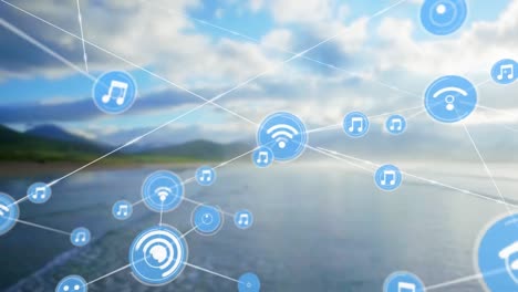 Animation-of-network-of-digital-icons-against-aerial-view-of-beach-and-clouds-in-the-blue-sky