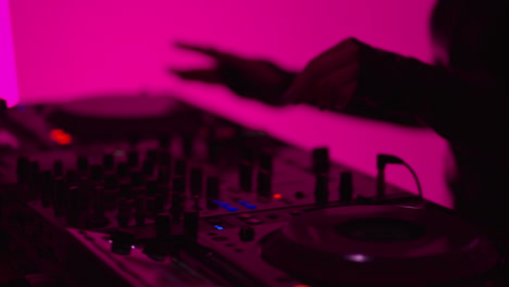 dj mixing music on turntables at a nightclub