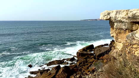 fuertes olas del mar azul golpeando las rocas del acantilado