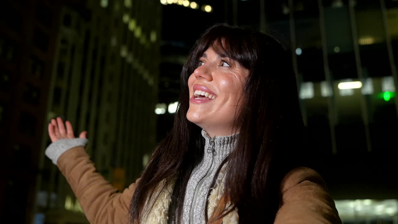 Giovane donna che sorride e ride in città di notte