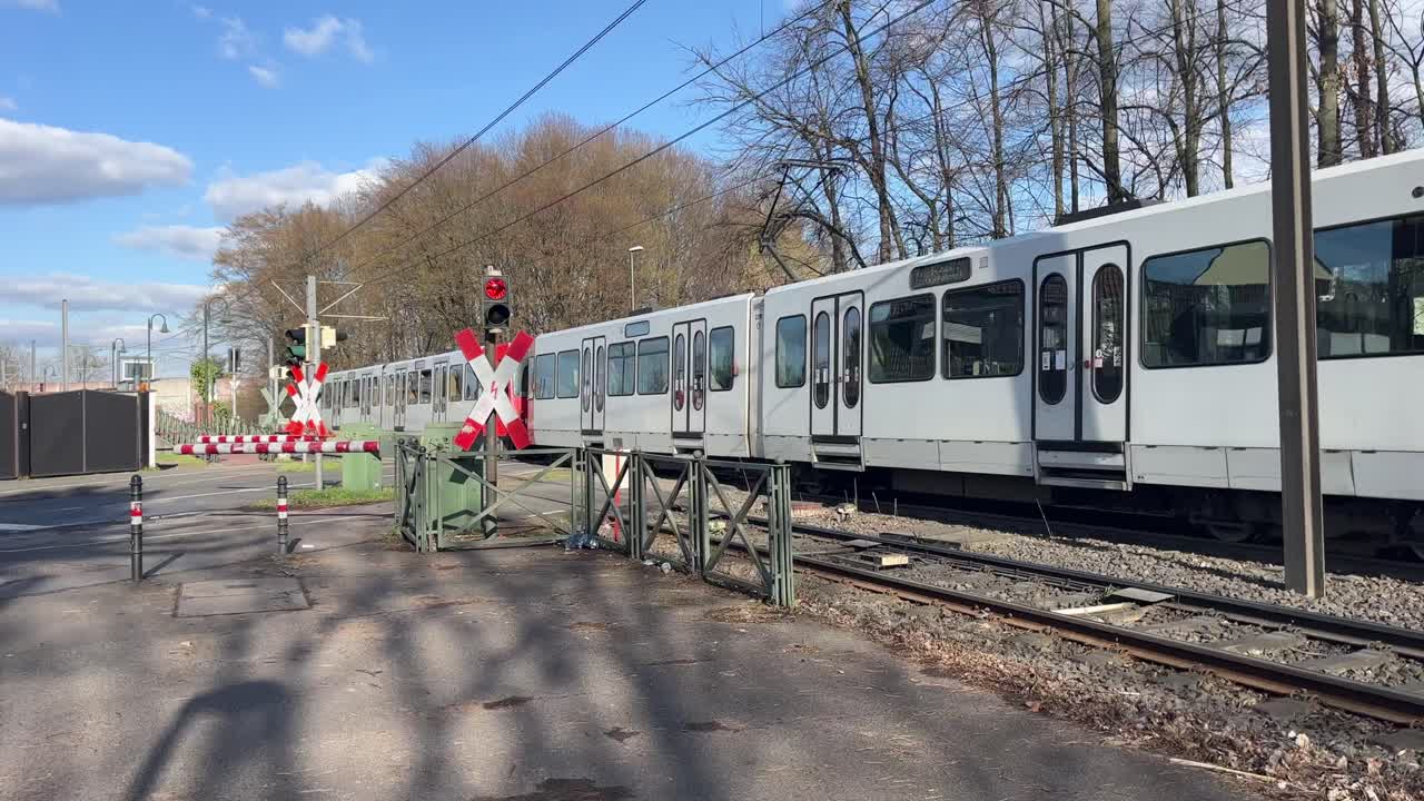 빨간색 트램은 고가도로 대기 차량이 없는 장벽이 있는 도로 위의 정류장에서 출발합니다.