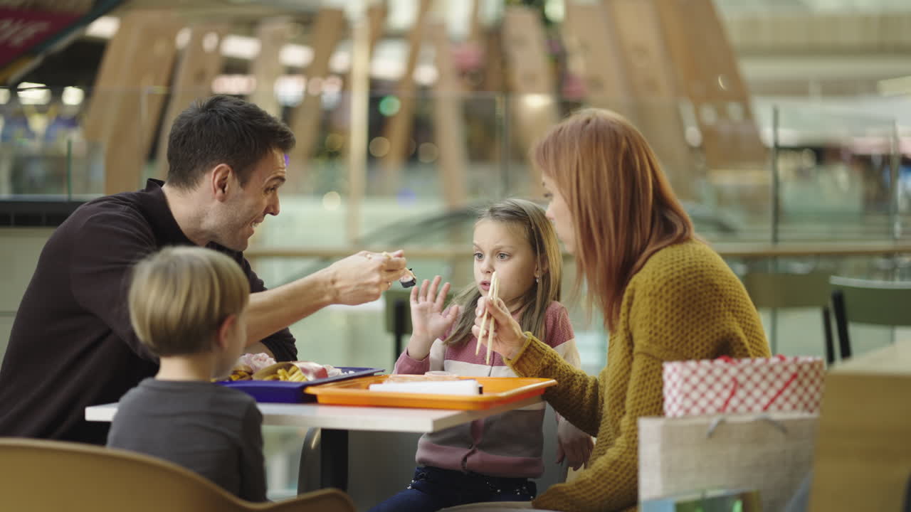 Famiglia che mangia in un'area ristorazione