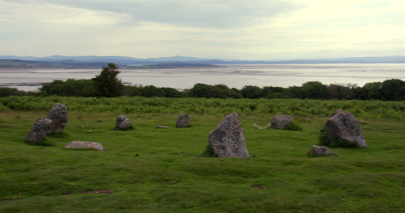 Wide panning shot of Birkrigg stone circle with Morecambe Bay in background near Ulverston
