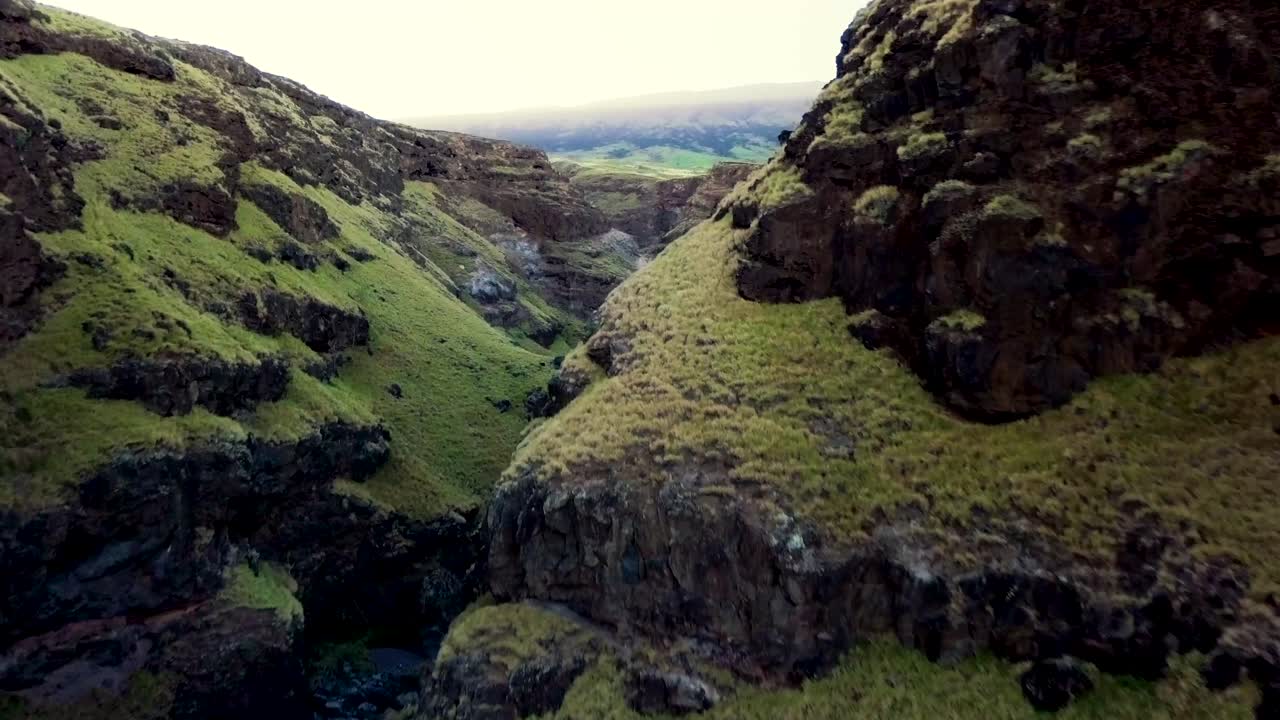 dolly en el vuelo ascendente de drones entre dos crestas revela un impresionante cañón y paisaje montañoso en maui, hawai
