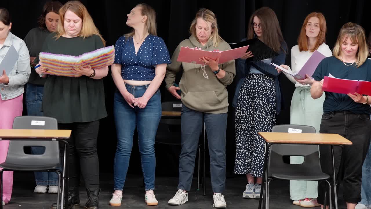 Amateur theatre performers learning their lines, panning left locked-off