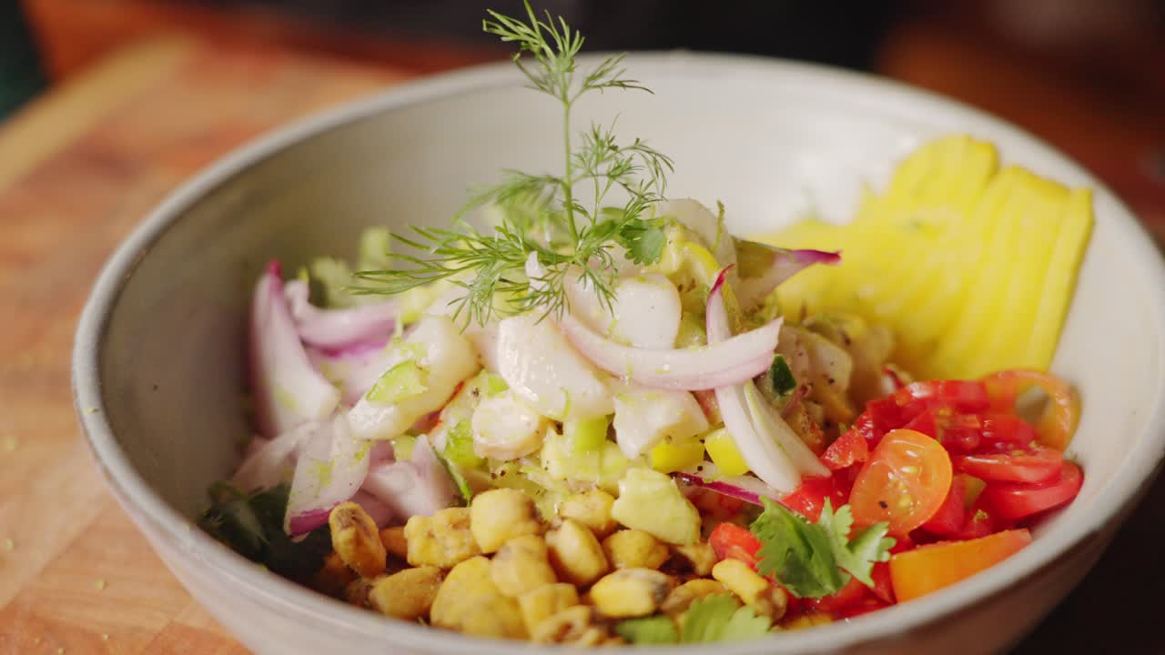 primer plano cinematográfico de una deliciosa ensalada de marisco peruana, plato de entrada de ceviche con ingredientes frescos y coloridos y adornado con frondas de hinojo frondoso