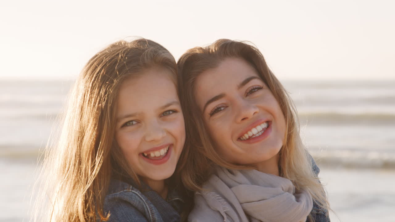 retrato de madre e hija caminando juntos por la playa de invierno