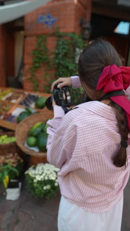 mujer tomando una foto de frutas en un mercado