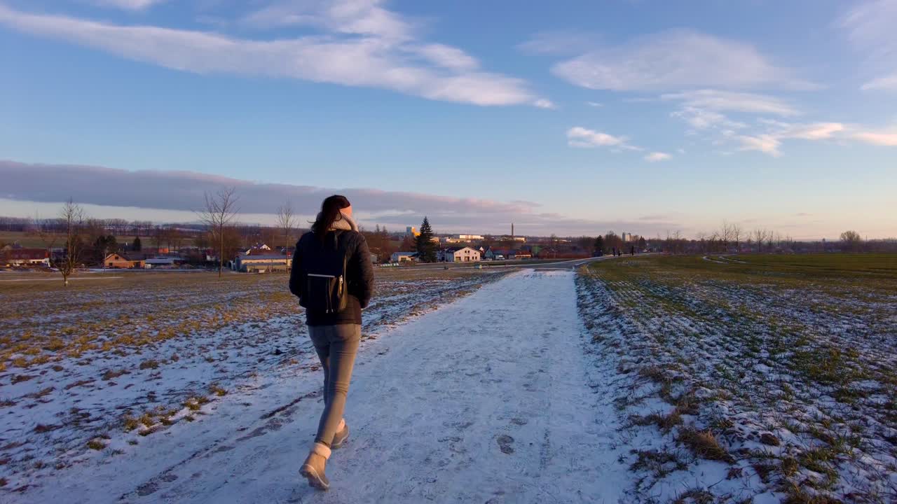 겨울 원더랜드의 시골 기쁨: 낙천적인 소녀의 모험으로 가득 찬 슬로우 모션으로 석양의 눈 덮인 햇살 가득한 들판을 거닐다