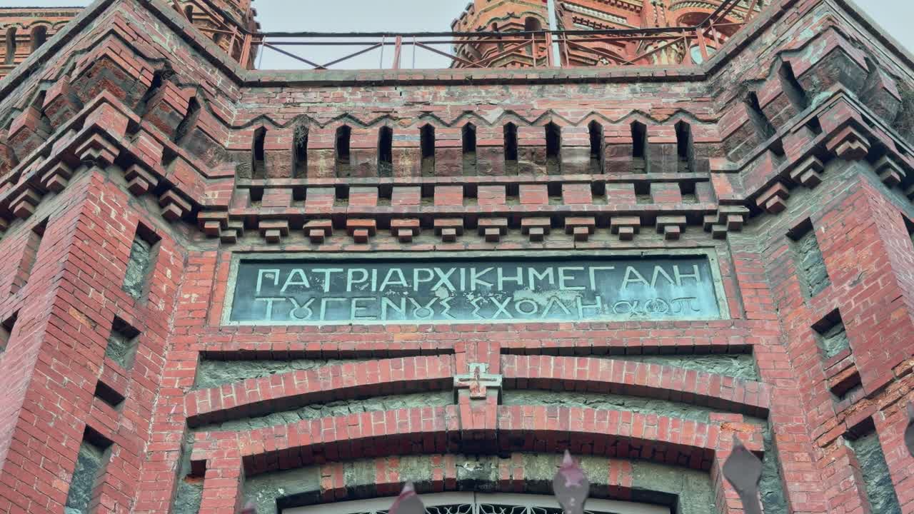 A low-angle, 4K cinematic footage captures the majestic structure of the historic Phanar Greek Orthodox College (Φαναριώτικη Μεγάλη του Γένους Σχολή) in Istanbul, Turkey, often referred to as 'The Red