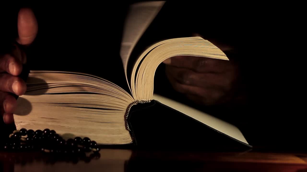 성경과 함께 손으로 신에게 기도하는 남자 검은 배경으로 기도하는 캐리비안 남자 스톡 비디오