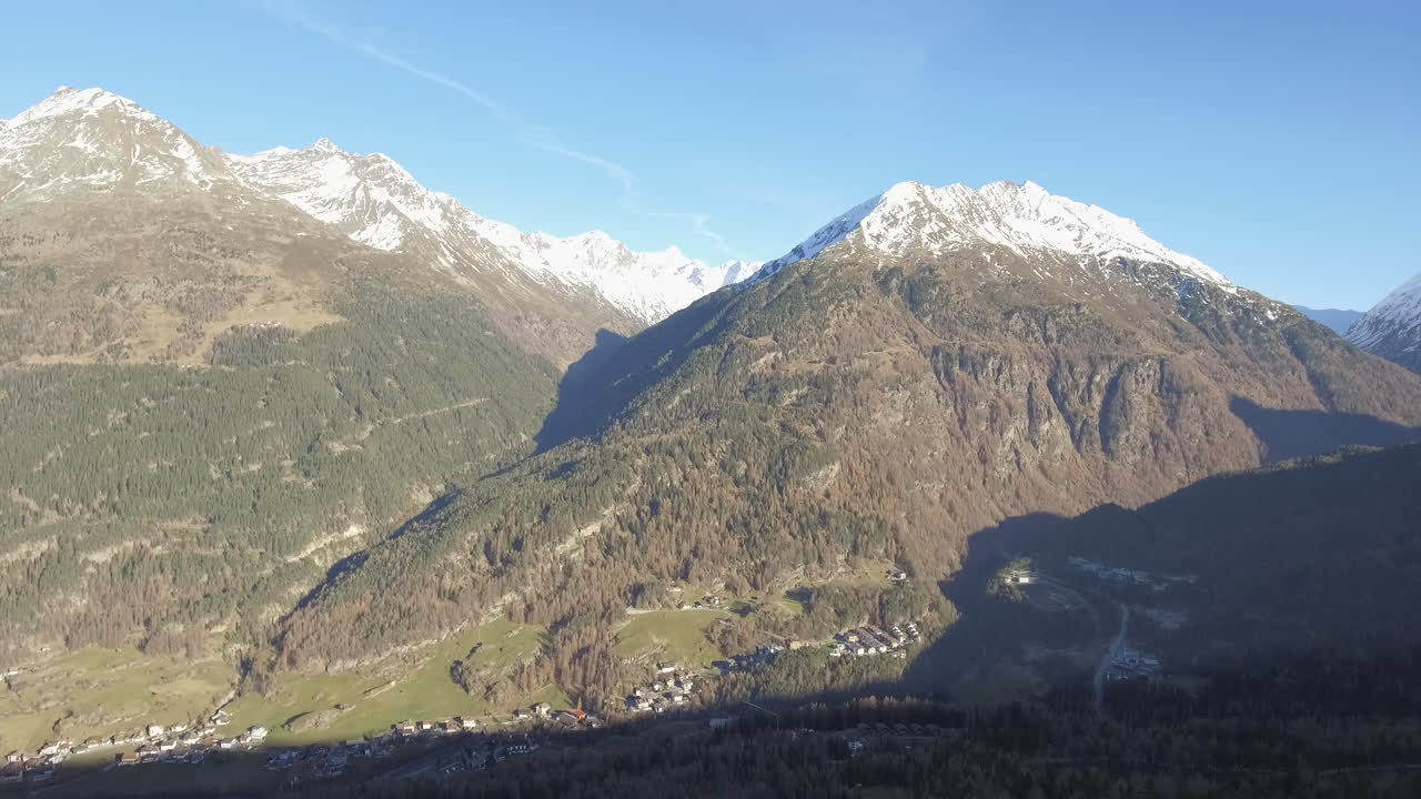 Drone Rising Up From Behind Treeline revealing Snow Covered Mountains, Solden Austria. 4K