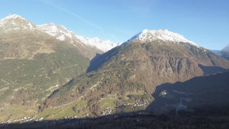 Drone Rising Up From Behind Treeline revealing Snow Covered Mountains, Solden Austria. 4K
