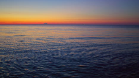 Puesta-De-Sol-En-El-Mar-Reflejándose-En-La-Superficie-Del-Agua-Al-Amanecer.-Tranquilas-Olas-Del-Océano-Azul