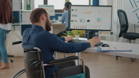 paralized manager working in start up business office sitting in wheelchair