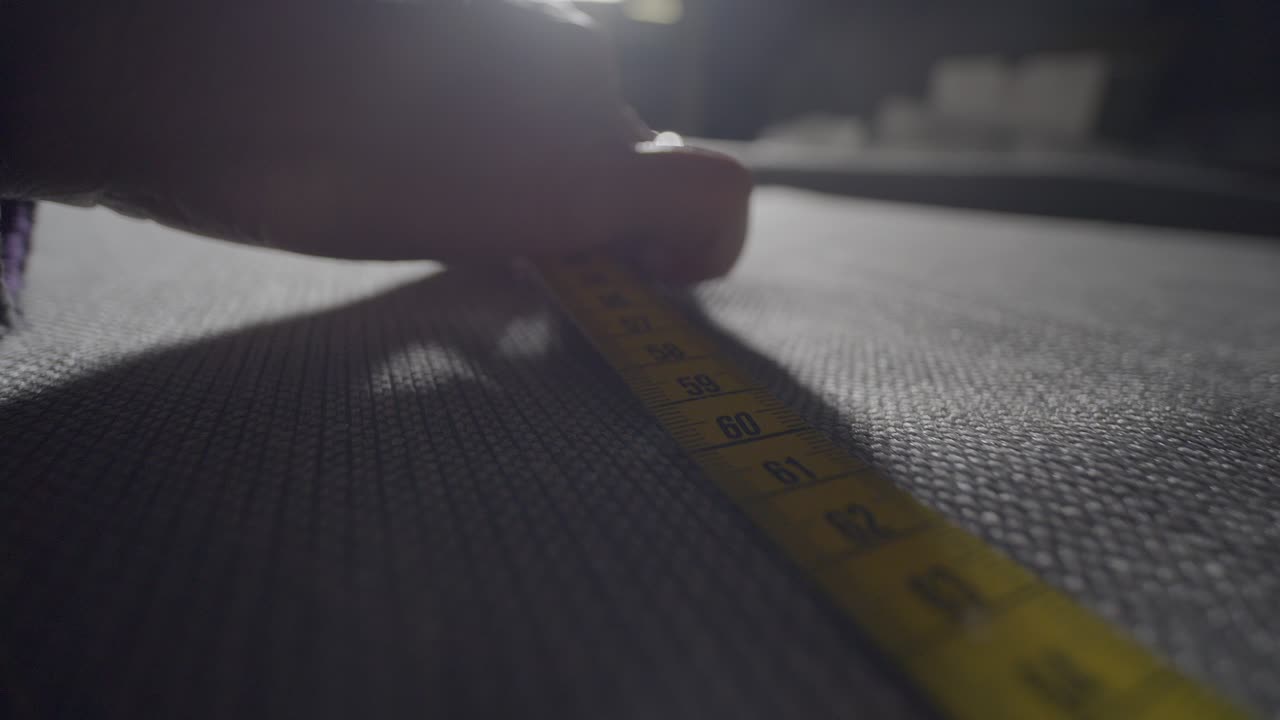 Dressmaker Taking Measure Of Fabric To Design Cloth
