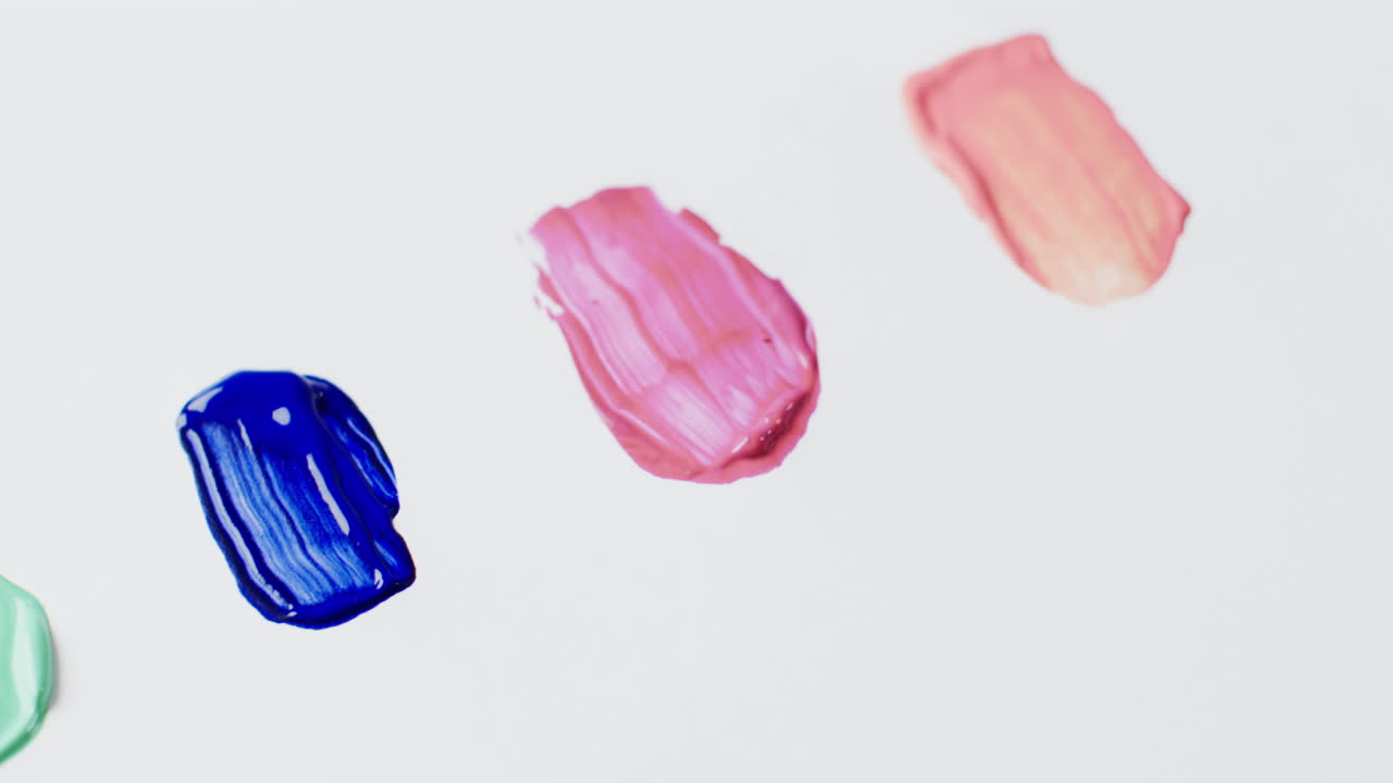 primer plano de formas de pintura multicolores sobre fondo blanco con espacio de copia, cámara lenta