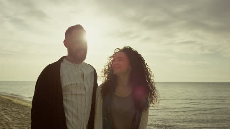amantes felices caminando por la playa al atardecer. una pareja hispana disfruta de la costa.