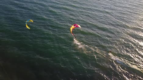 drone footage of kitesurfers surfing together in the sea of galilee