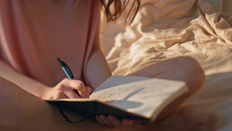 closeup peaceful girl resting home alone. hands holding pen writing daily diary