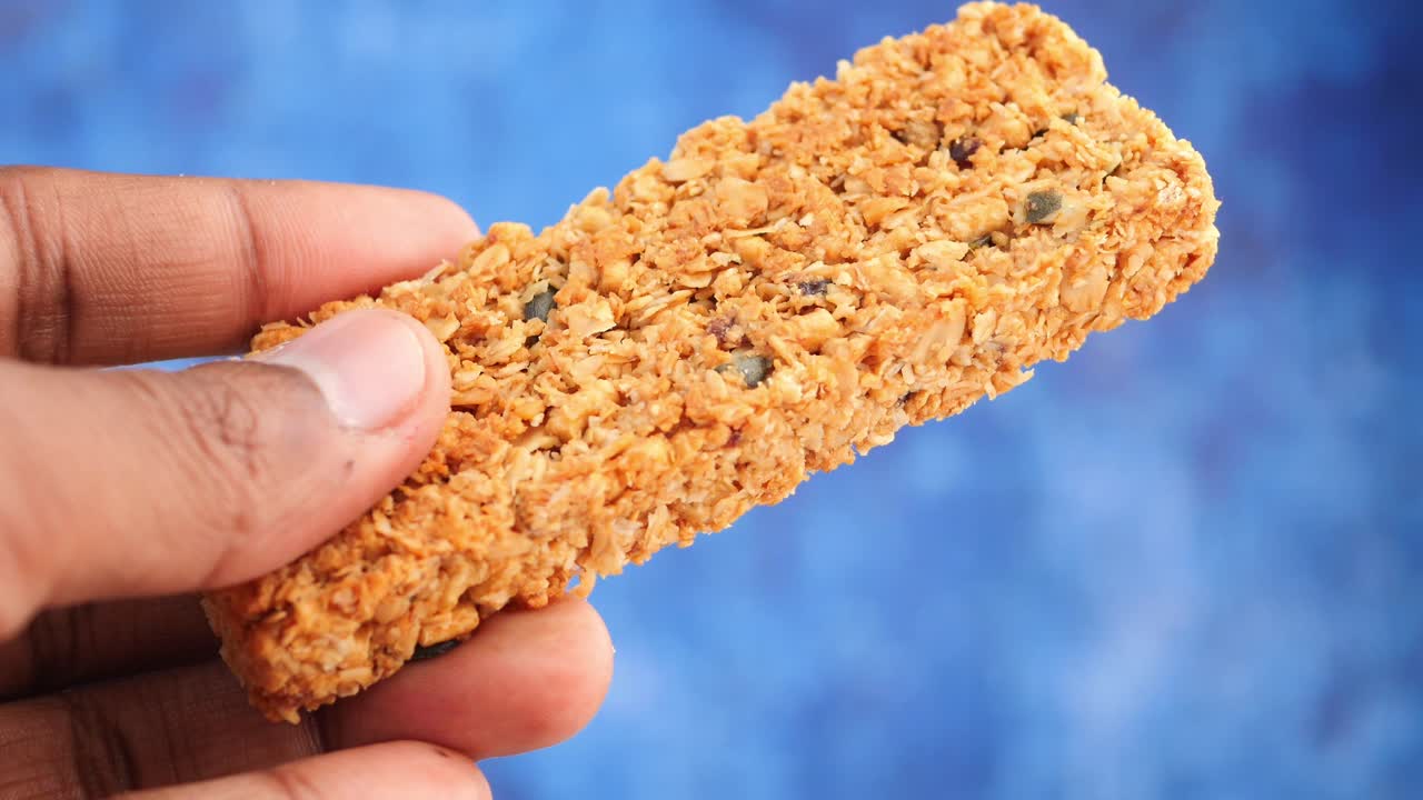 그라놀라 바 를 들고 있는 손