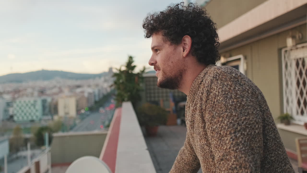 Hombre en balcón con vistas a la ciudad