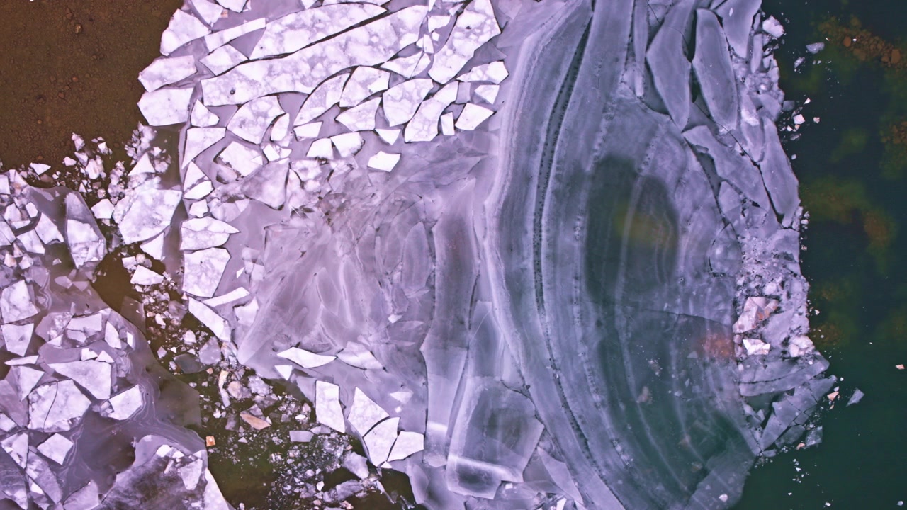 Drone footage of a calm winter landscape with frozen Great Lakes ice viewed from above.