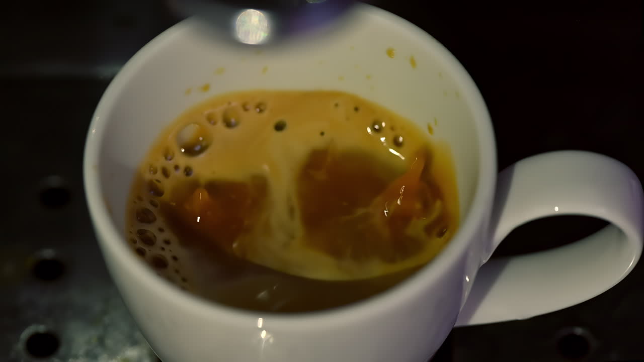 Watch as a skilled barista brews rich espresso, showcasing the deep flavors and creamy texture. The process highlights the artistry of coffee-making in a cozy cafe setting