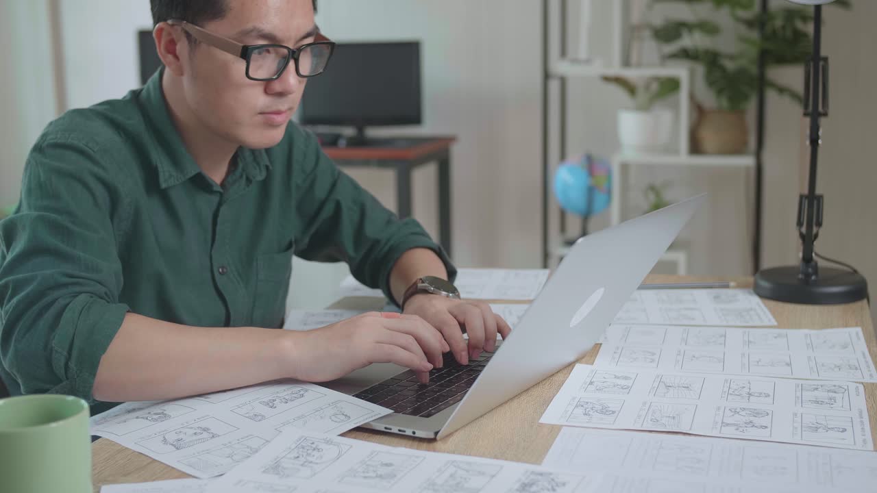 Asian Man Works With Laptop Computer And Storyboard. Video Editing, Comics Compilation, Application Ui Or Game Plot