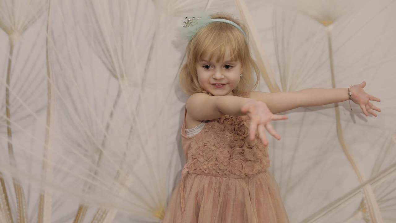 feliz niña de tres años hacer caras y bailar. niño rubio lindo