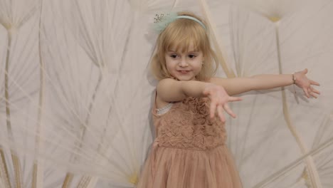 Happy-three-years-old-girl-make-faces-and-dancing.-Cute-blonde-child