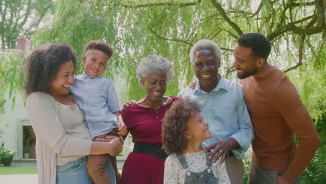 Portrait-Of-Smiling-Multi-Generation-Family-At-Home-In-Garden-Together