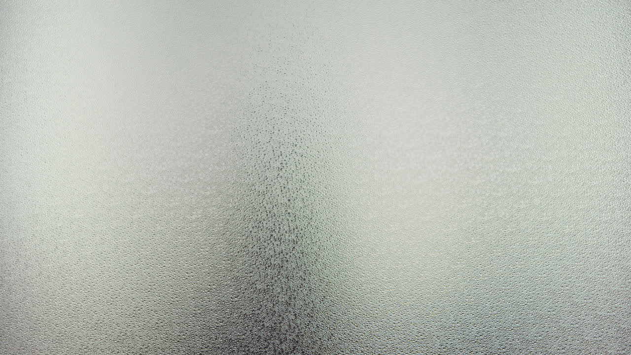 A female silhouette behind the frosted window dances slowly