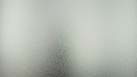 a female silhouette behind the frosted window dances slowly