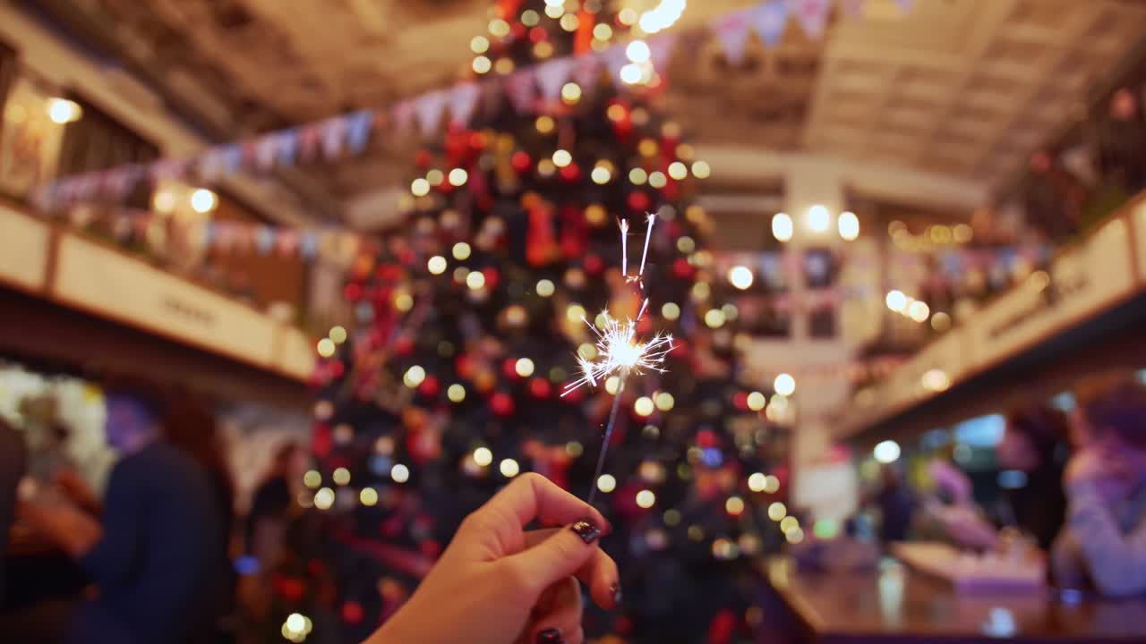 Ripresa POV di una stella filante sullo sfondo di un albero di Natale, slow motion