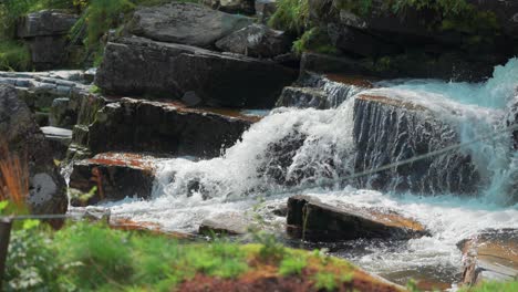 Wild-trout-climbs-upstream-on-the-cascade-at-the-Tvindefossen-waterfall,-Norway