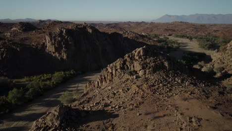 Dry-river-bed-and-rock-formations,-arid-wilderness-of-Namibia