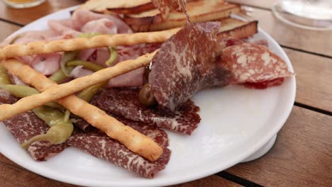 fork picking salami from antipasta plate