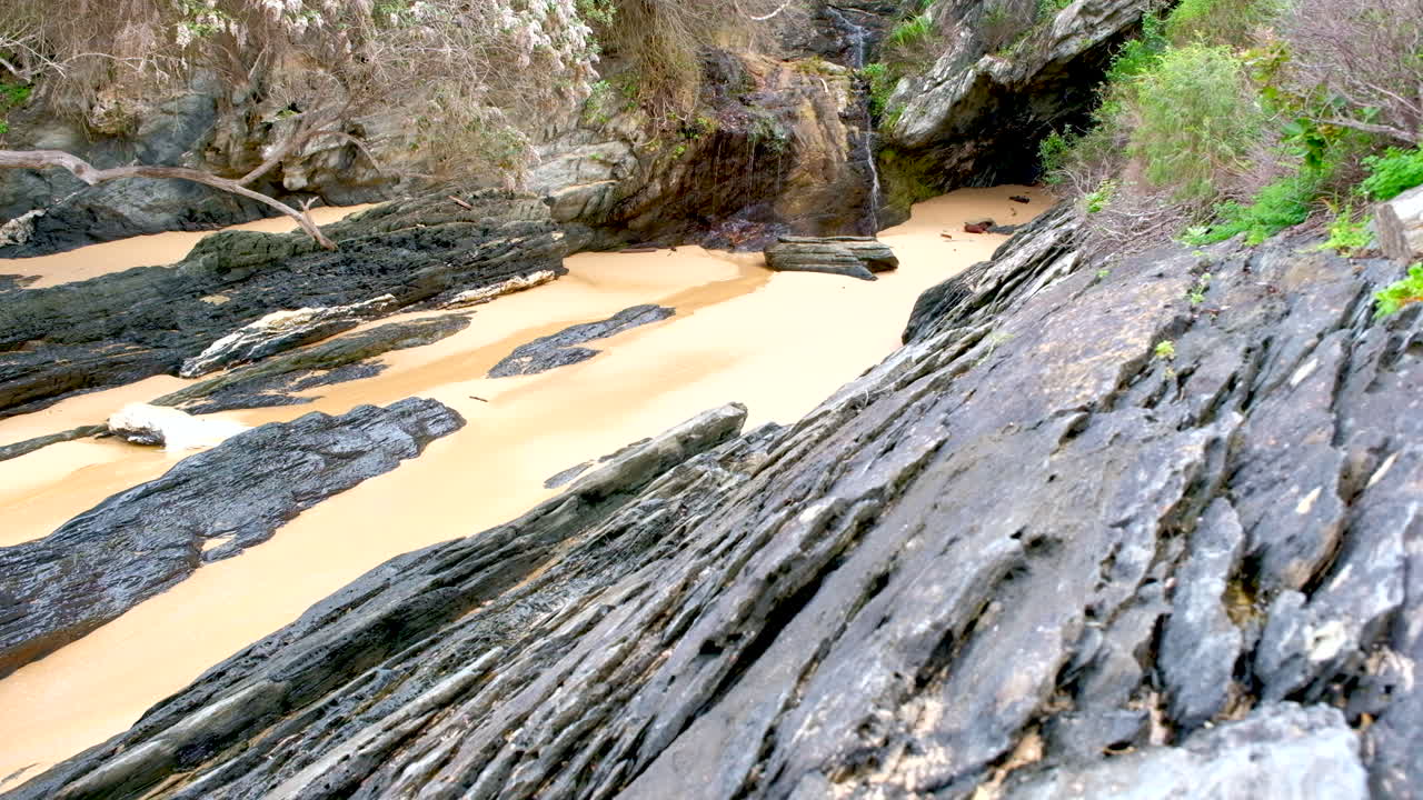 Small waterfall on rocky coastline along walkway trail at Storms River mouth