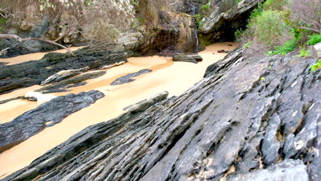 small waterfall on rocky coastline along walkway trail at storms river mouth