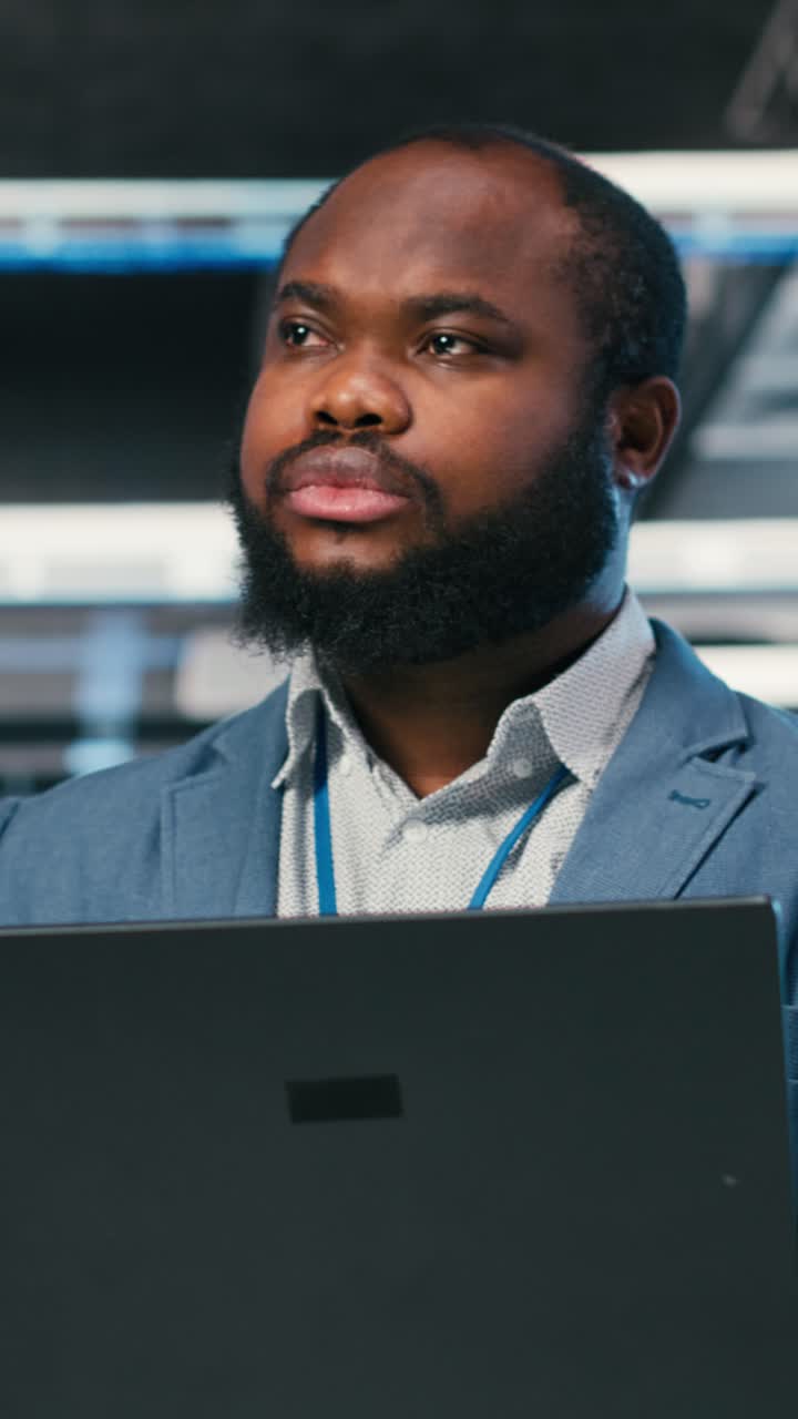 Vertical video Software developer in server farm using laptop, doing network management